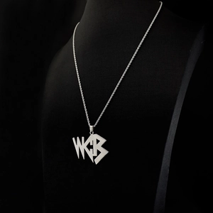 Vue détaillée du pendentif lettre WCB argenté sur une chaîne corde sur un buste
