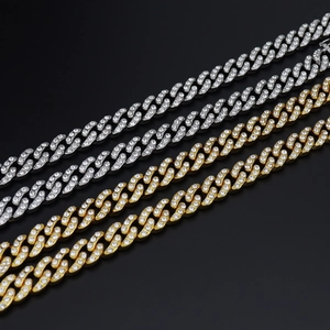 Vue détaillée de chaînes Cuban link de 12mm en or et argent avec micro-pavage de zircons