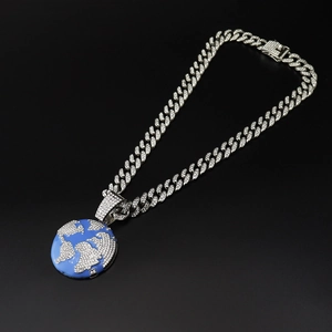 Macro shot of iced out world map pendant with blue enamel and Cuban link chain