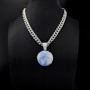 Detailed close-up of iced-out Earth globe pendant with diamonds on a Cuban link chain