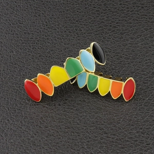 Macro shot of colorful enamel rainbow teeth grills on a black textured background