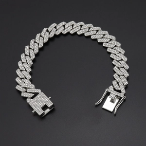 Detailopname van een zilveren cubaanse ketting met dichte diamanten en een baksluiting