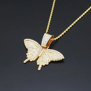 Détail du pendentif papillon hip hop avec strass blancs et chaîne en or torsadée