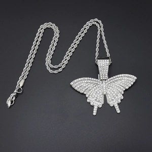Détail du pendentif papillon hip hop serti de strass sur une chaîne de style torsadée