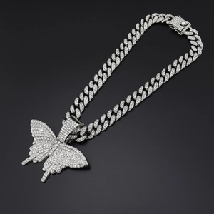 Détail de la chaîne cubaine argentée avec pendentif papillon et strass transparents