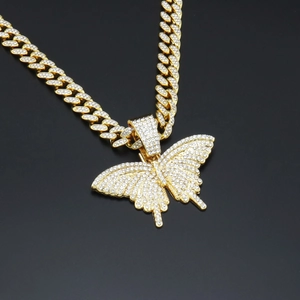 Gros plan d'un pendentif papillon doré avec chaîne cubaine de style hip-hop