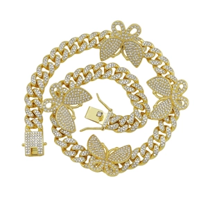 Détail du collier chaîne cubaine avec papillons et strass blancs sur finition dorée mate