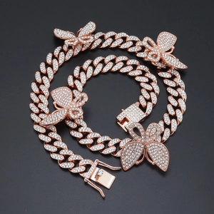 Vue détaillée d'une chaîne cubaine en or rose avec des breloques papillon en diamant