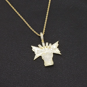 Detailed macro view of iced-out Really Rich letters pendant on gold rope chain