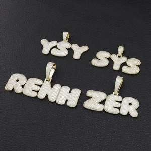 Détail de pendentifs hip-hop plaqués or avec micro-pavage de zircons blancs brillants