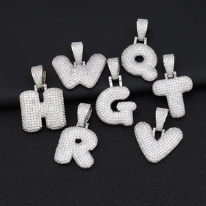 Dettaglio di ciondoli a lettere bubble iced out con zirconi incastonati scintillanti