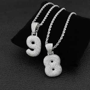 Gros plan de pendentifs chiffres hip-hop avec zircone cubique sur velours noir