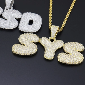Vue macro du pendentif lettre SYS dorée avec zircone cubique sertie en micro-pavage