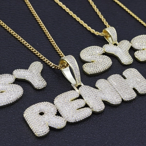 Vue macro du collier à lettres bulles avec zircons et chaîne torsadée dorée brillante