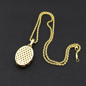 Collier hip hop plaqué or avec pendentif ovale et chaîne torsadée sur fond en cuir noir