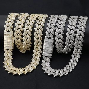 Détail des chaînes cubaines de 13mm en or et argent avec zircons sur fond noir profond
