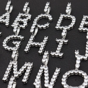 Pendentifs alphabet en argent et zircon avec serti micro-pavé sur fond de cuir noir