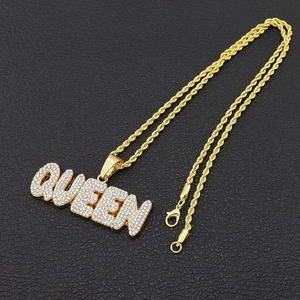 Λεπτομέρεια macro από χρυσό μενταγιόν QUEEN με κρύσταλλα pavé σε αλυσίδα τύπου σχοινί