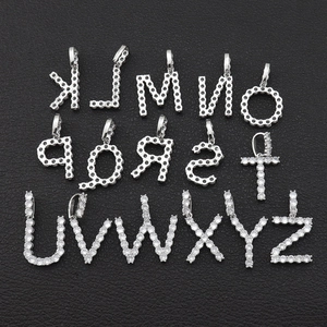 Vue macro de pendentifs lettres K à Z en zircone argentée sur cuir noir texturé
