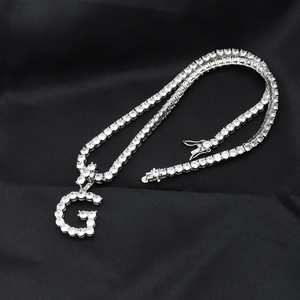 Détail de la chaîne tennis argentée et du pendentif G avec zircons blancs sur soie noire