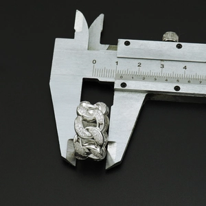 Detailed view of 13mm Cuban link ring width measured with a metal caliper tool