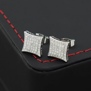 Macro shot of square micro-pave zircon stud earrings on a premium black leather box