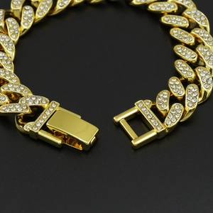Macro view of 12mm gold plated Cuban link chain with paved rhinestones and snap clasp