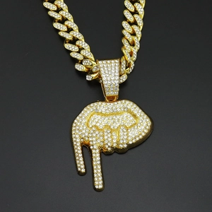 Vue détaillée du pendentif lèvres givrées sur une grosse chaîne cubaine dorée style hip hop
