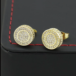 Gros plan de boucles d'oreilles hip hop dorées avec zircons blancs sur cuir noir
