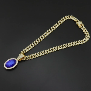 Detail of hip-hop cuban chain with oval blue gemstone pendant and micro paved crystals