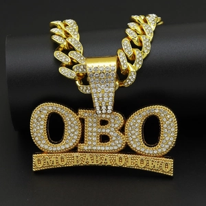 Macro shot of gold hip hop pendant with OBO letter engraving and iced out crystals
