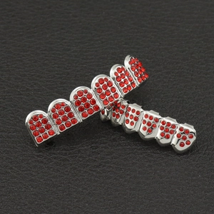 Macro view of silver plated hip hop teeth grillz set with red rhinestones on black leather