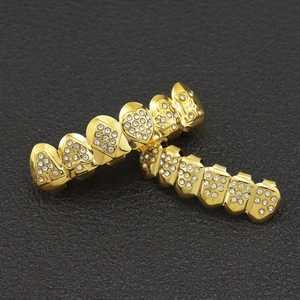 Macro shot of gold plated hip hop grillz with sparkling rhinestones on black background