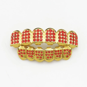 Hip hop gold plated teeth grillz set with red iced out crystals on white background