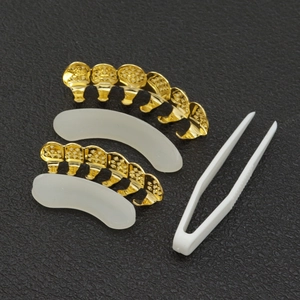 Detail view of 18K gold plated hip hop grillz set with tweezers and silicone fixing bars