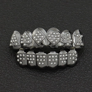 Detail of gunmetal hip hop grillz featuring poker card symbols and inlaid rhinestones