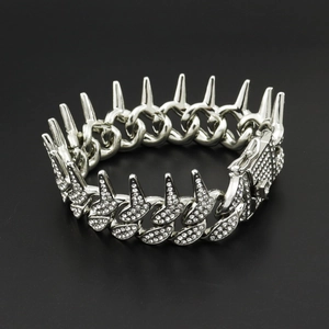 Macro shot of silver hip-hop Cuban link bracelet with punk spikes and full diamond inlay