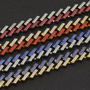 Vista macro di catene cubane hip hop da 15mm con strass colorati su sfondo nero testurizzato