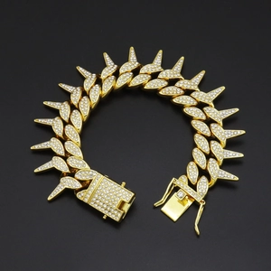 Detailed macro view of gold-plated spiked Cuban chain bracelet with iced out crystals
