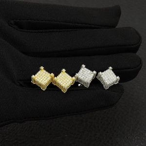Macro shot of iced-out hip hop square stud earrings in gold and silver finish