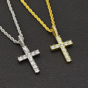 Detailed macro view of gold and silver iced out cross pendants with rope chains