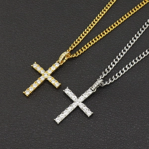 Detail of hip hop iced out cross pendants in gold and silver with cuban link chains