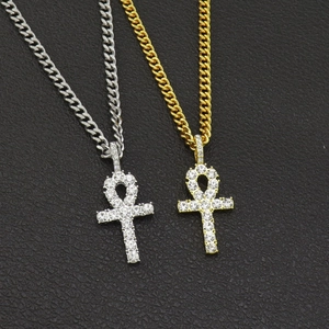 Close-up of iced-out Ankh cross pendant with sparkling crystals on black leather
