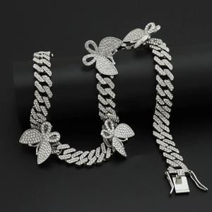 Détail de la chaîne cubaine sertie de diamants avec pendentifs papillon et strass