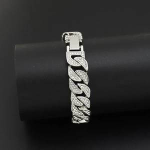 Macro view of silver-toned Cuban link bracelet with iced-out leaf pattern rhinestones