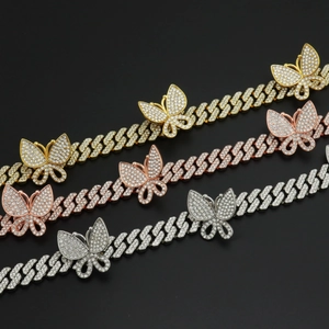Vue macro détaillée de chaînes cubaines 12mm avec trois pendentifs papillon en trois couleurs