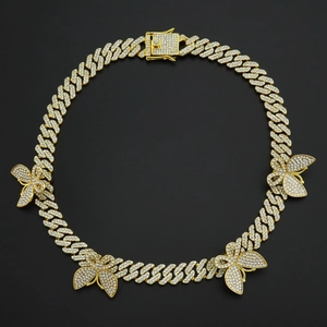 Détail d'une chaîne cubaine de 12 mm avec breloques papillons et fermoir en diamant