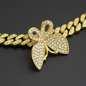 Vue macro de la chaîne cubaine dorée avec pendentif papillon serti de strass