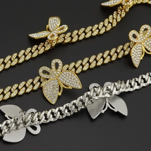 Vue détaillée des chaînes Cuban Link or et argent avec pendentifs papillons sertis de zircons