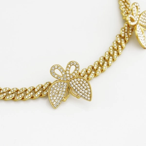 Détail d'une chaîne cubaine de 8mm plaquée or avec des ornements de papillons en strass